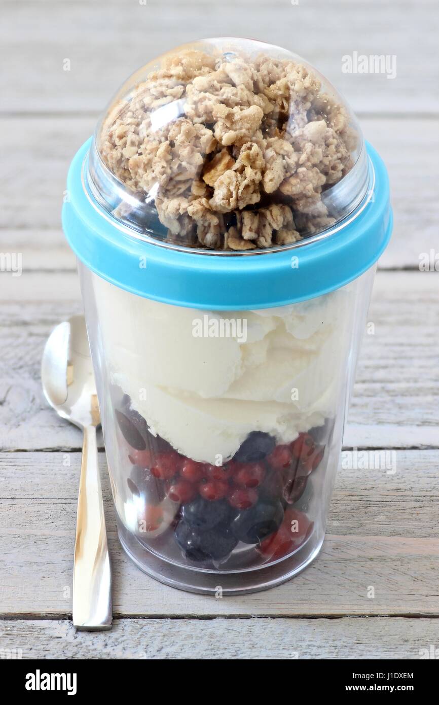 yogurt with fresh garden berries and cereals in reusable picnic