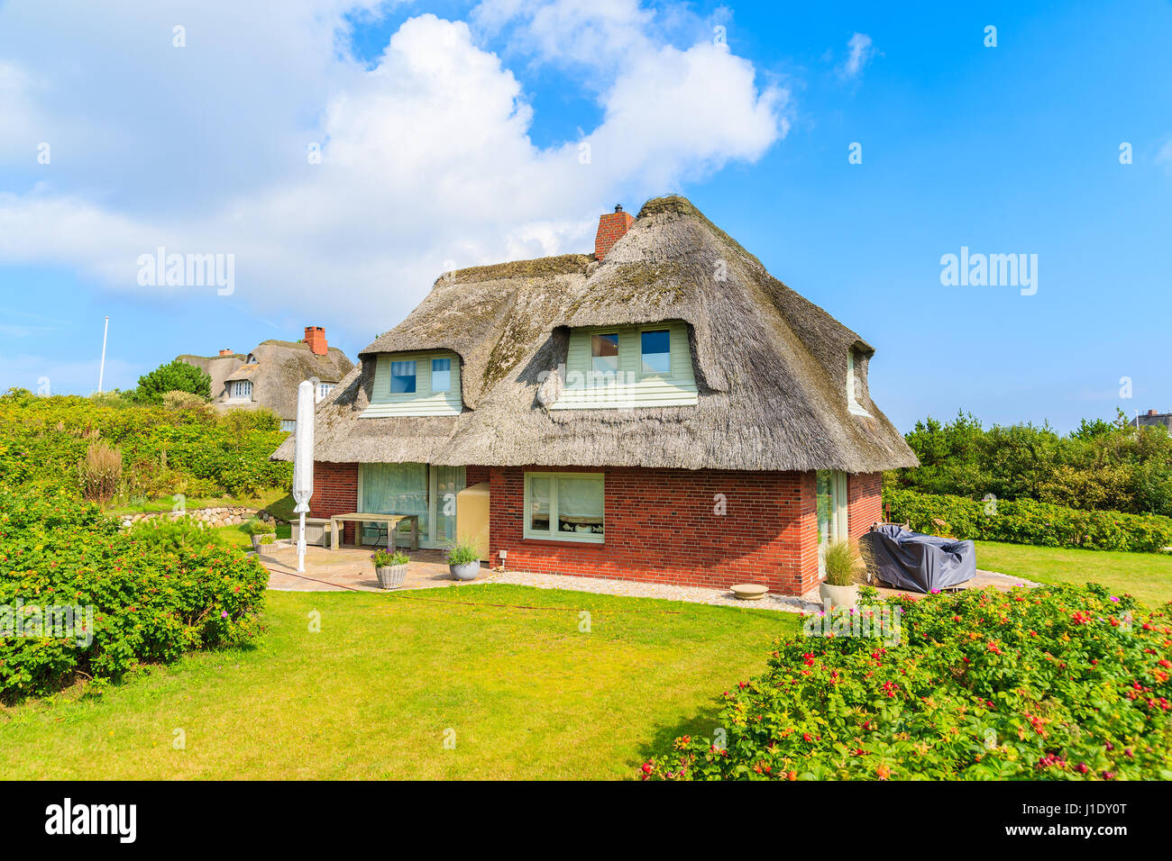 Typical red brick house in Westerheide village with straw roof, Sylt island, Germany Stock Photo