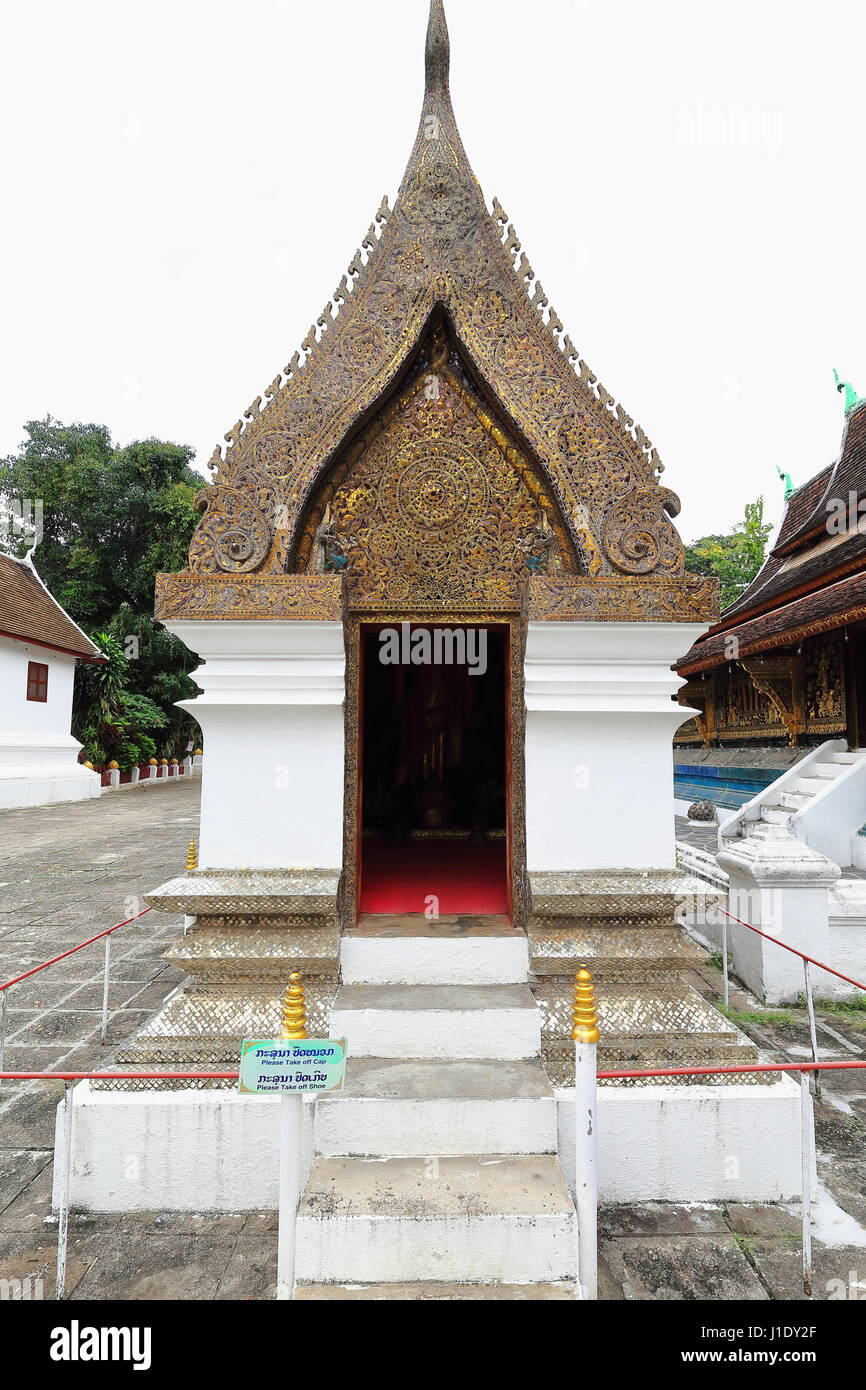 Standing Buddha chapel-pediment with colorful glass mosaics of flower motifs and two kinnaree-roof finials with Chofahs or mythological Nagas-bronze i Stock Photo