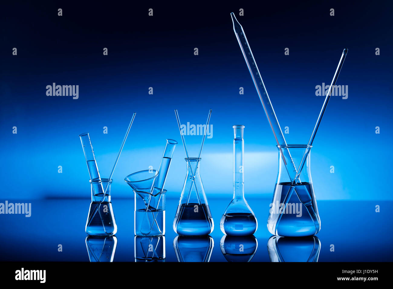 Modern laboratory equipment , set of different glassware on blue ...