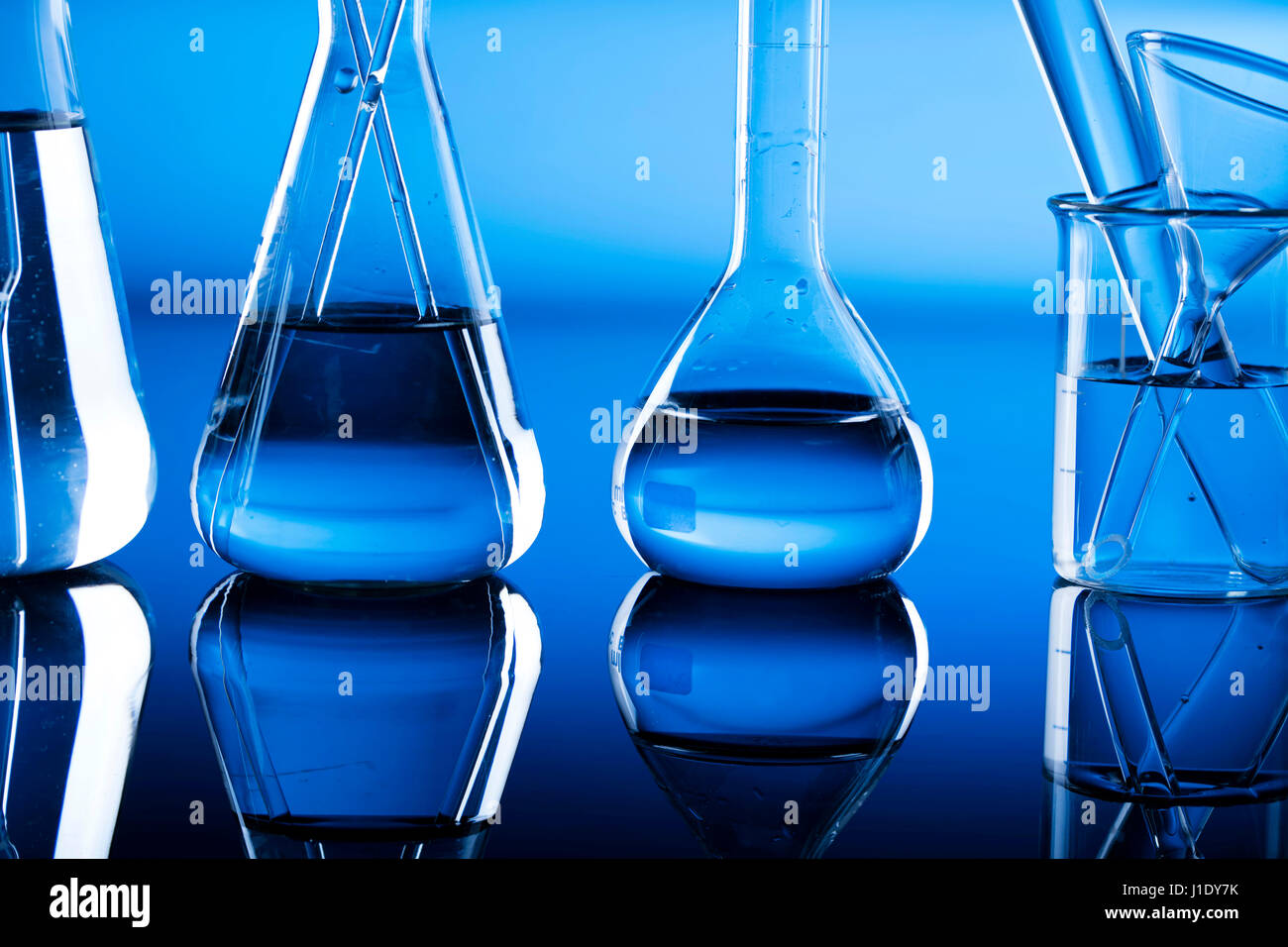 Modern laboratory equipment , set of different glassware on blue ...