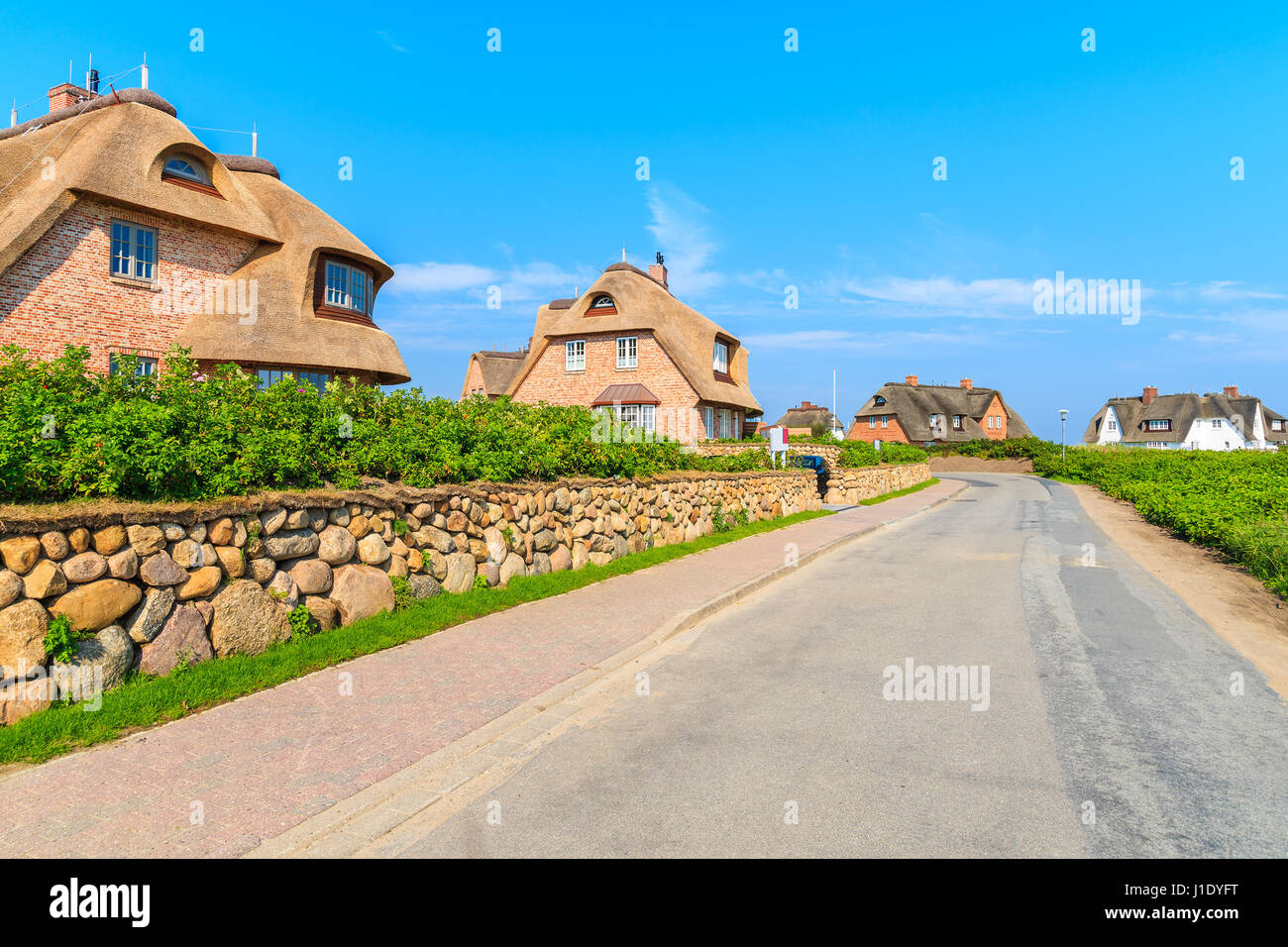 Typical Frisian red brick houses with straw roofs in Rantum village on southern coast of Sylt island, Germany Stock Photo