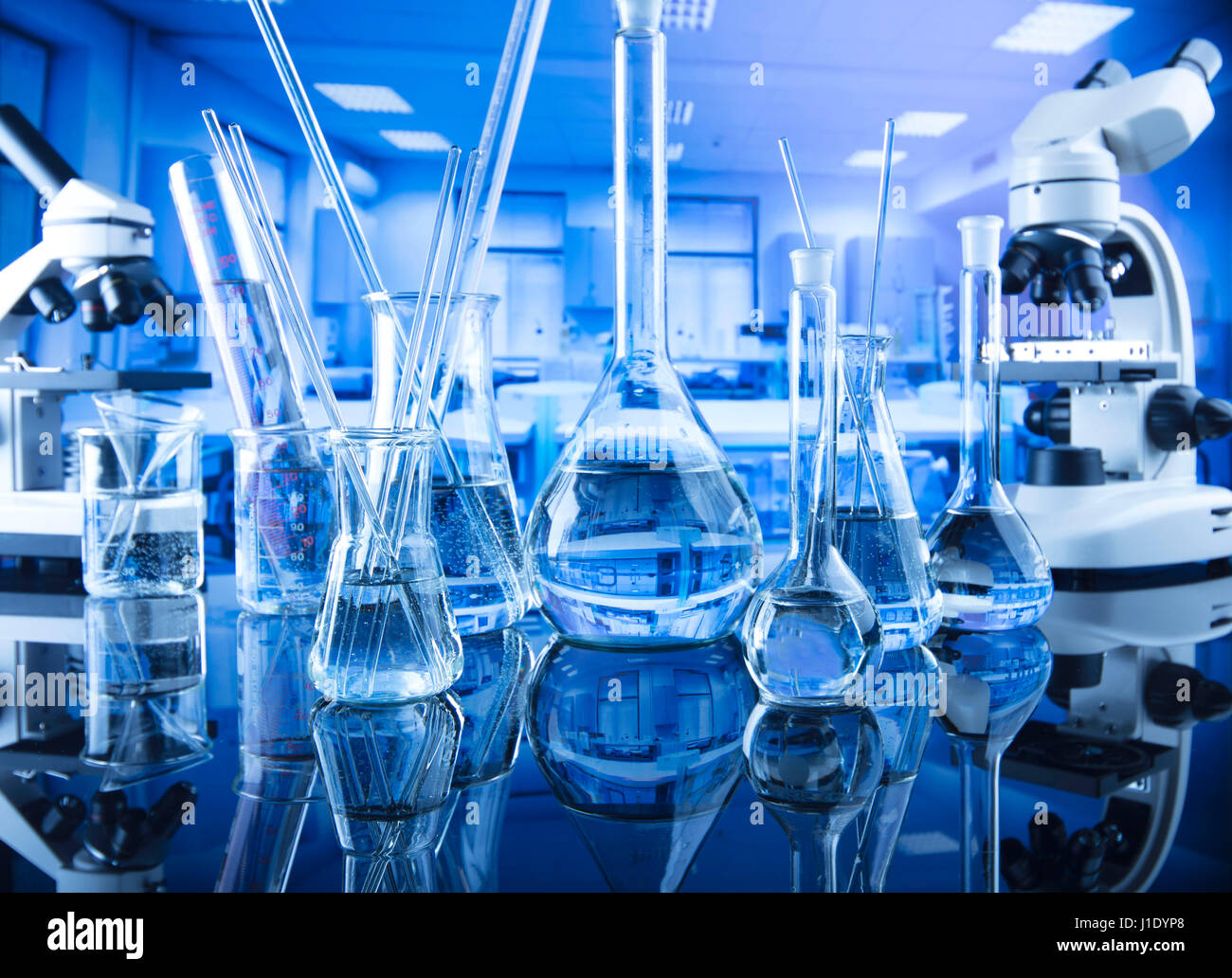 Modern laboratory  equipment , set of different glassware on blue background. Stock Photo