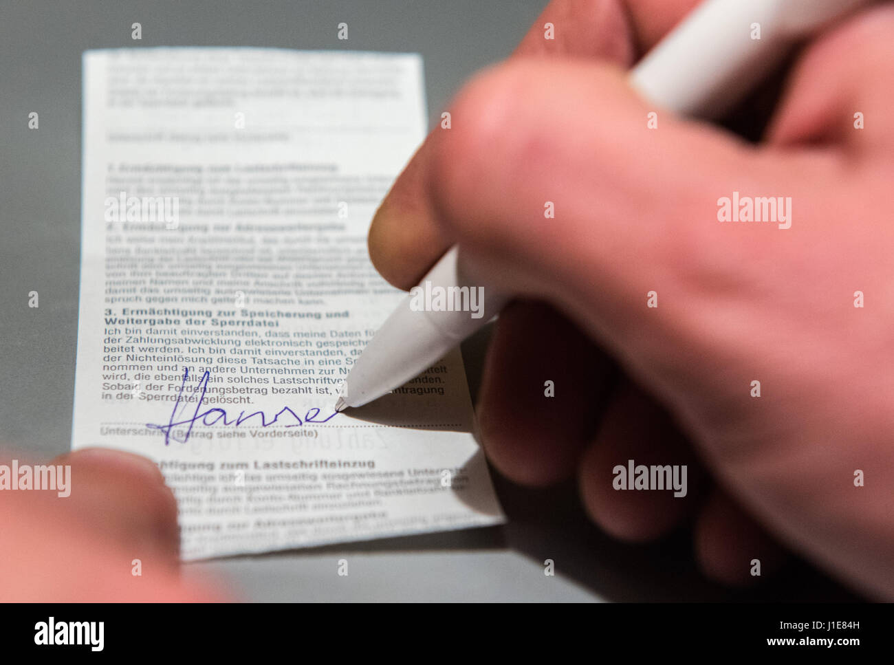 Hamburg, Germany. 20th Apr, 2017. ILLUSTRATION - A man signs an EC ticket which gives approval for a direct debit (posed scene) in Hamburg, Germany, 20 April 2017. Photo: Daniel Bockwoldt/dpa/Alamy Live News Stock Photo