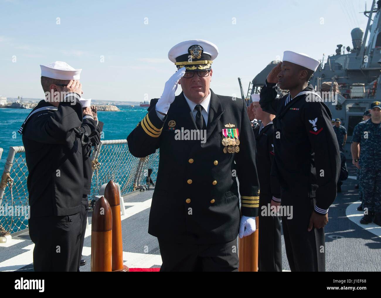 U.S. Navy Cmdr. Russell Caldwell is saluted by his crew during a routine change of command ceremony aboard USS Ross April 11, 2017 in Larnaca, Cyprus. Caldwell, led the ships missile assault on Syria on April 7th, turned over the helm to Cmdr. Bryan Gallo. Stock Photo
