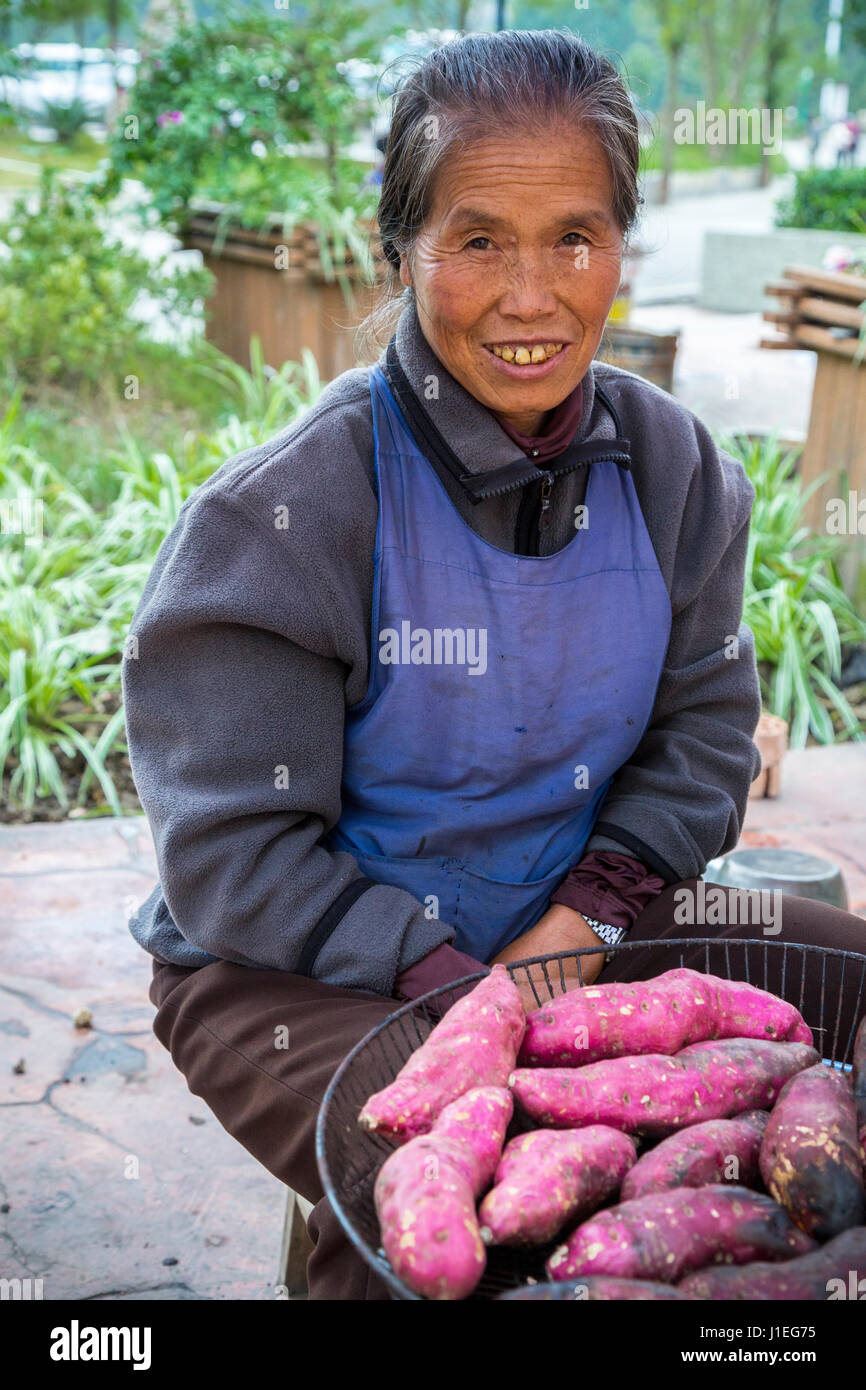 Guizhou Province, China.  Han Woman Selling Sweet Potatoes. Stock Photo