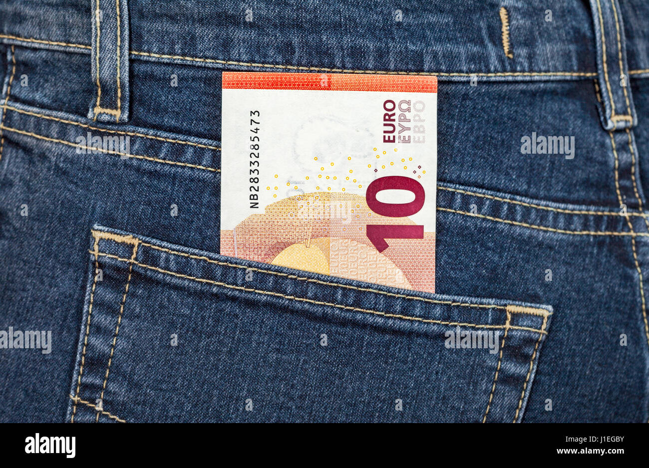 Banknote 10 euro sticking out of the back jeans pocket. Money for travel and shopping Stock Photo