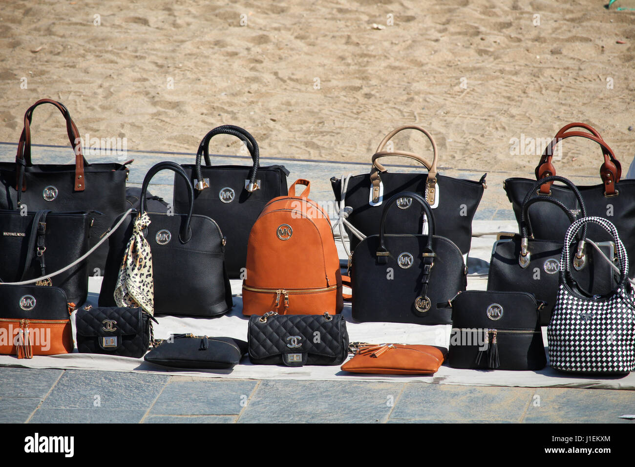BARCELONA/SPAIN - 15 APRIL 2017: False branded leather bags such as Michael Kors and Chanel sold on Barceloneta beach Stock Photo