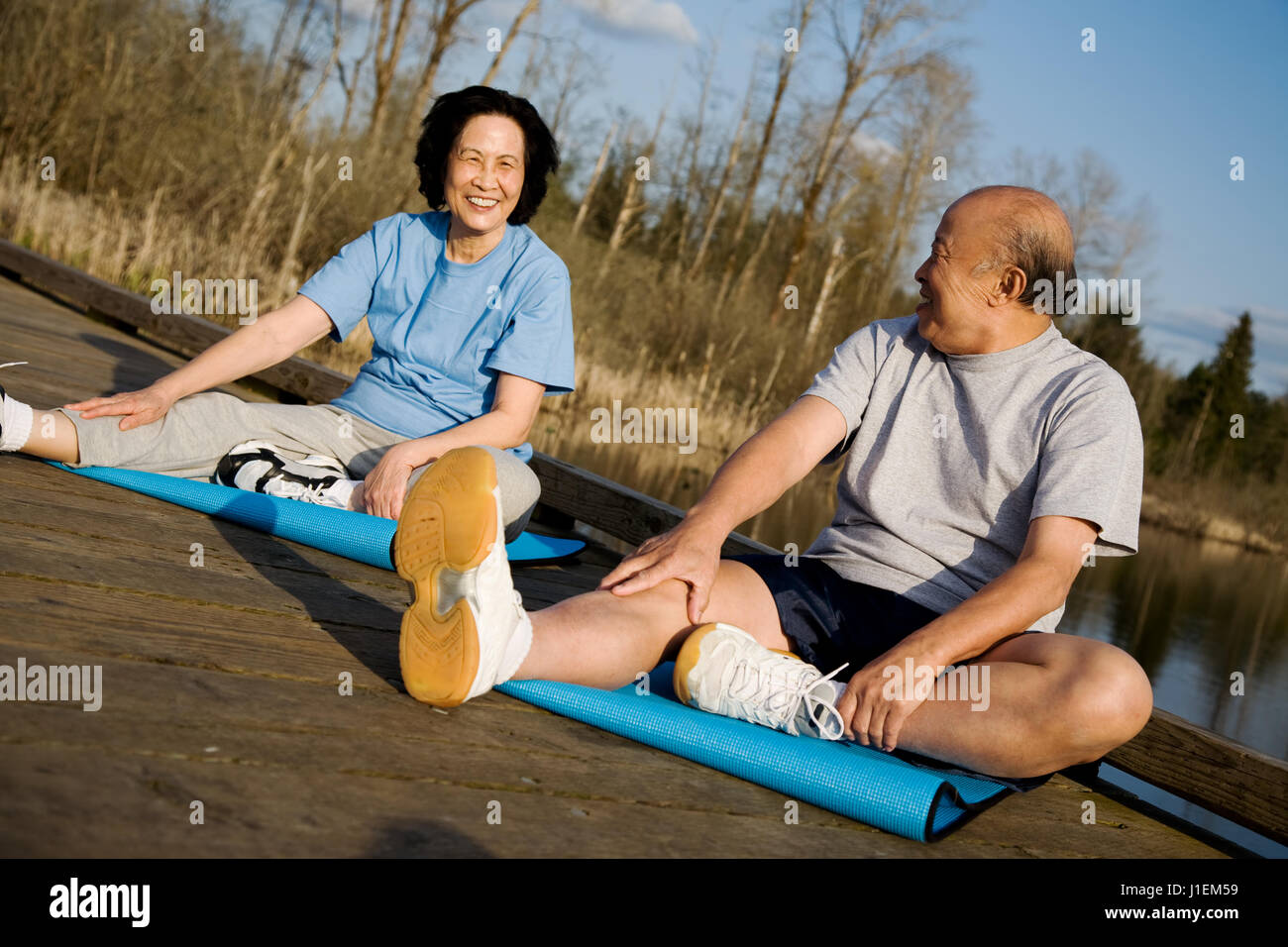 A senior asian couple stretching before exercise Stock Photo - Alamy