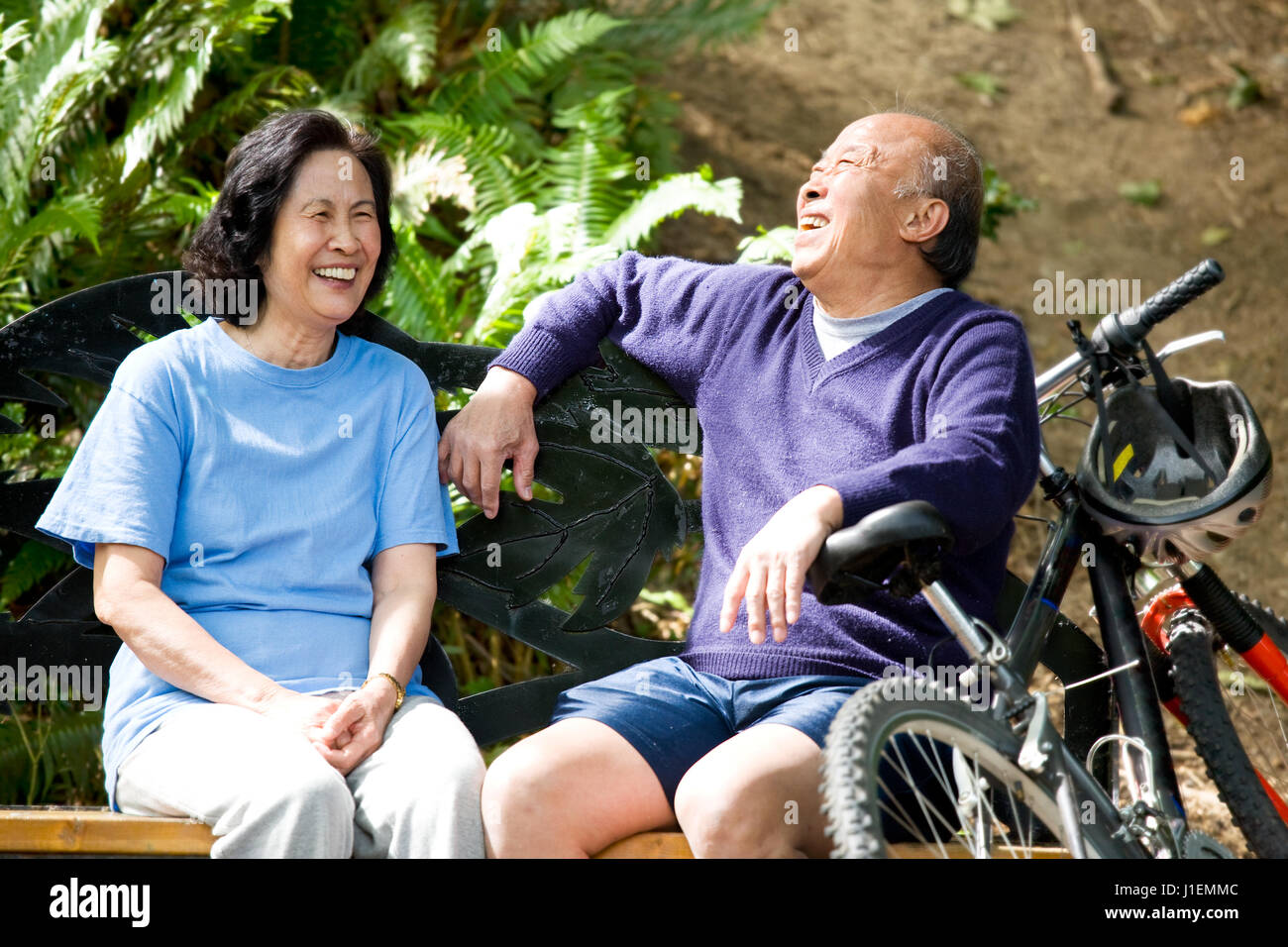 A shot of senior asian couple sitting on a bench at a park Stock Photo ...