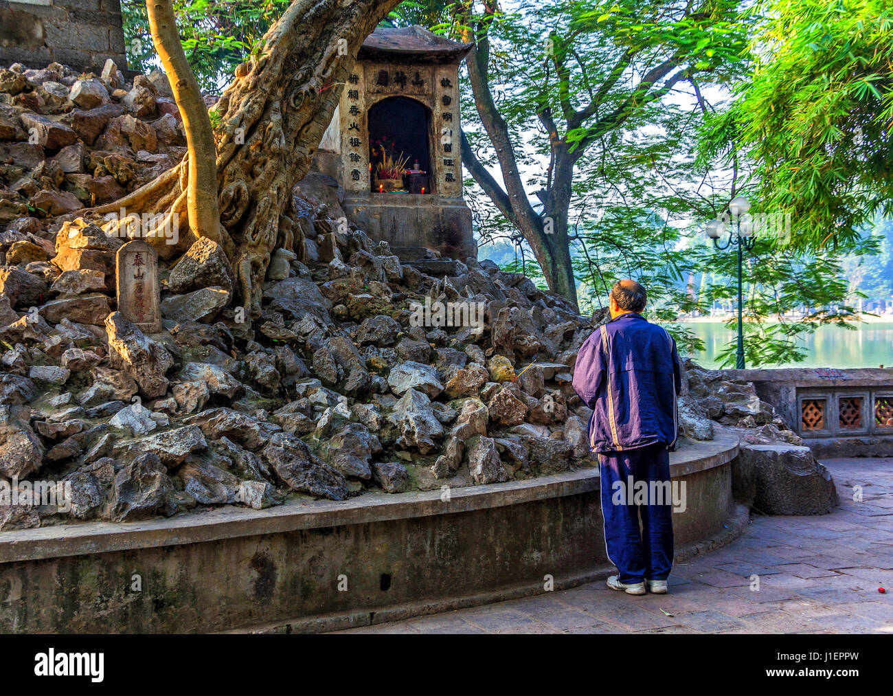 Man praying at a Buddhist shrine in Hanoi, Vietnam Stock Photo