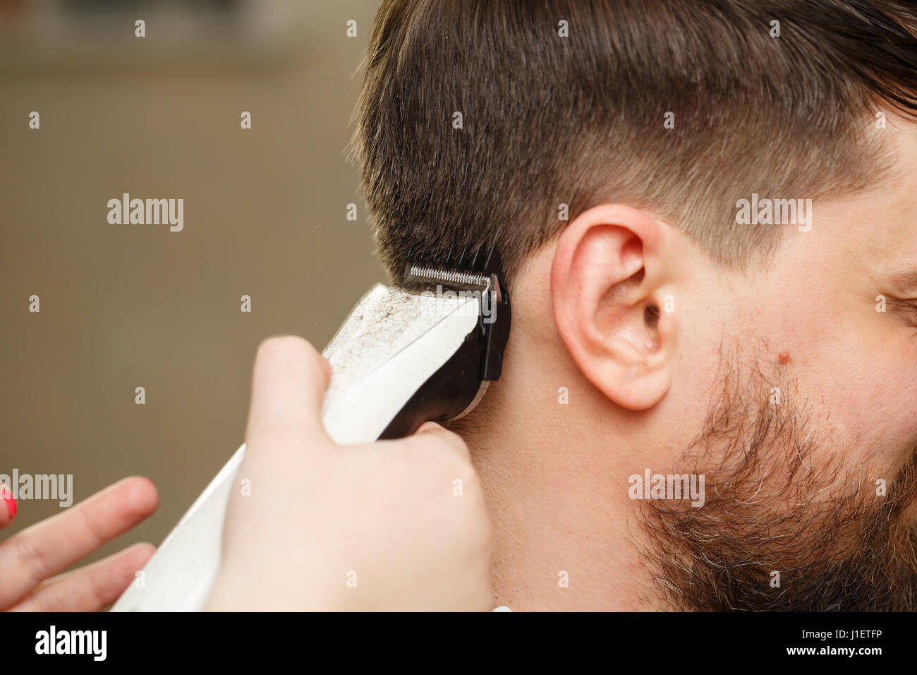 Professional hairdresser doing haircut men's hair. Cutting electric razor.  Beauty saloon. Male beauty. The client is a hipster Stock Photo - Alamy