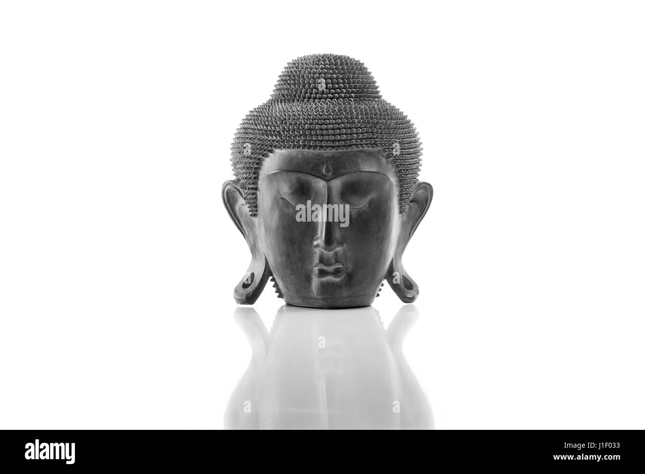 Buddha head on a white background, isolated and with reflection Stock