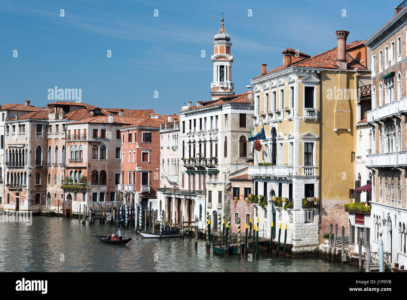 View from Rialto Bridge of gondola on Grand Canal and  tower of San Apostoli church in background, Venice Stock Photo