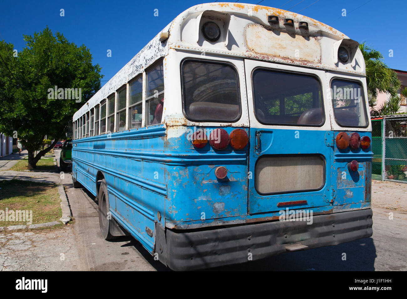 Typical old school bus parked in front of an old building on the Havana street. Cuba Stock Photo