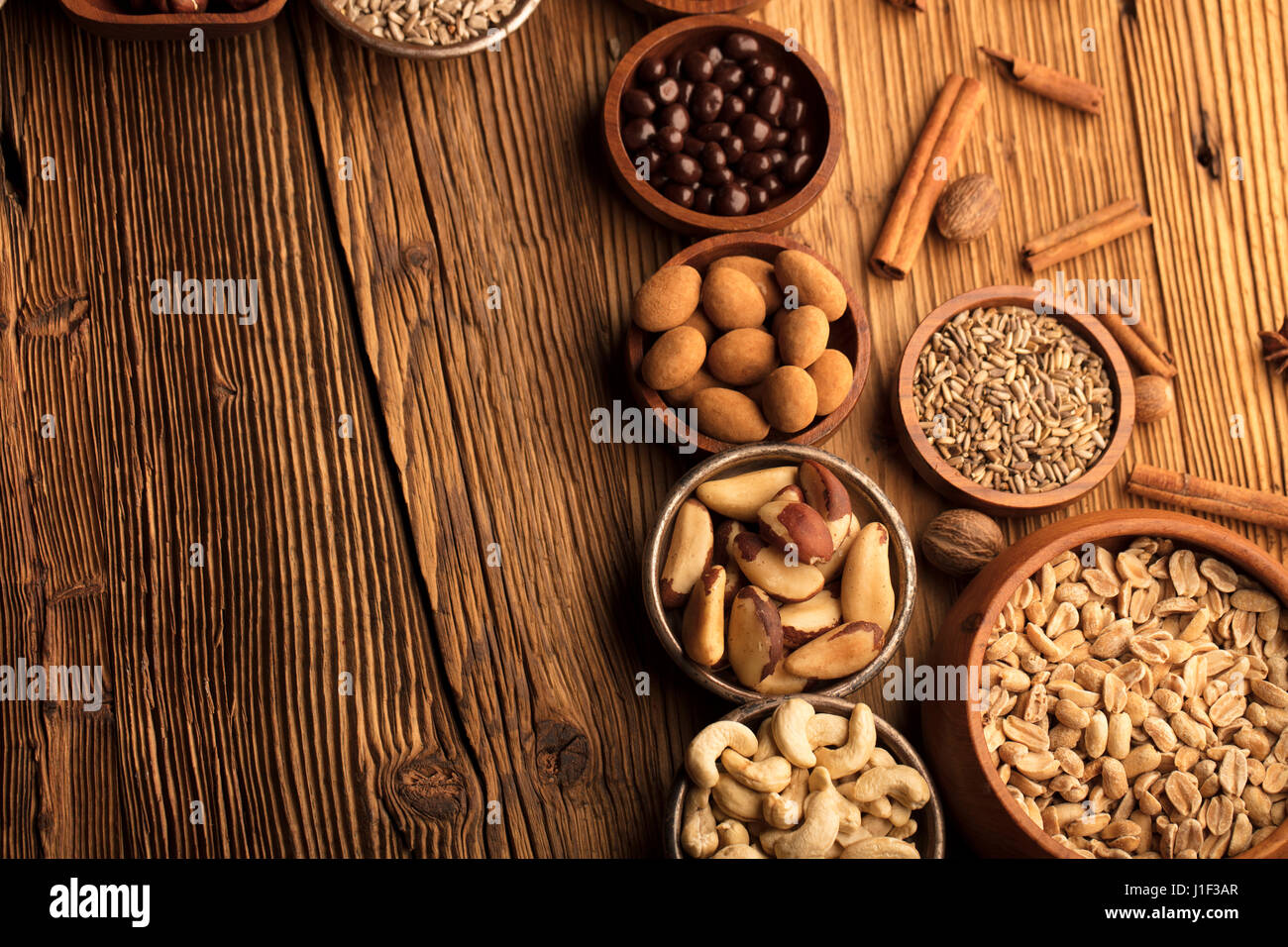 Different nuts in bowls on wooden table. Chocolate Stock Photo Alamy