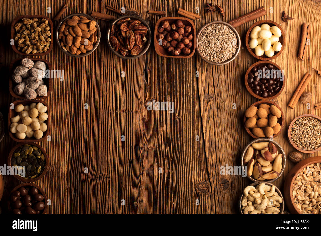 Different nuts in bowls on wooden table. Chocolate Stock Photo Alamy