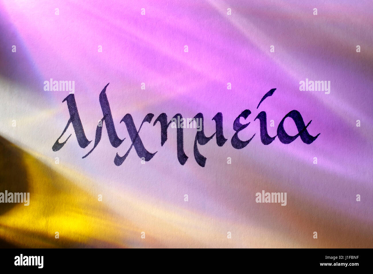 Handwritten word alchemy in greek script under colored lights. Greek