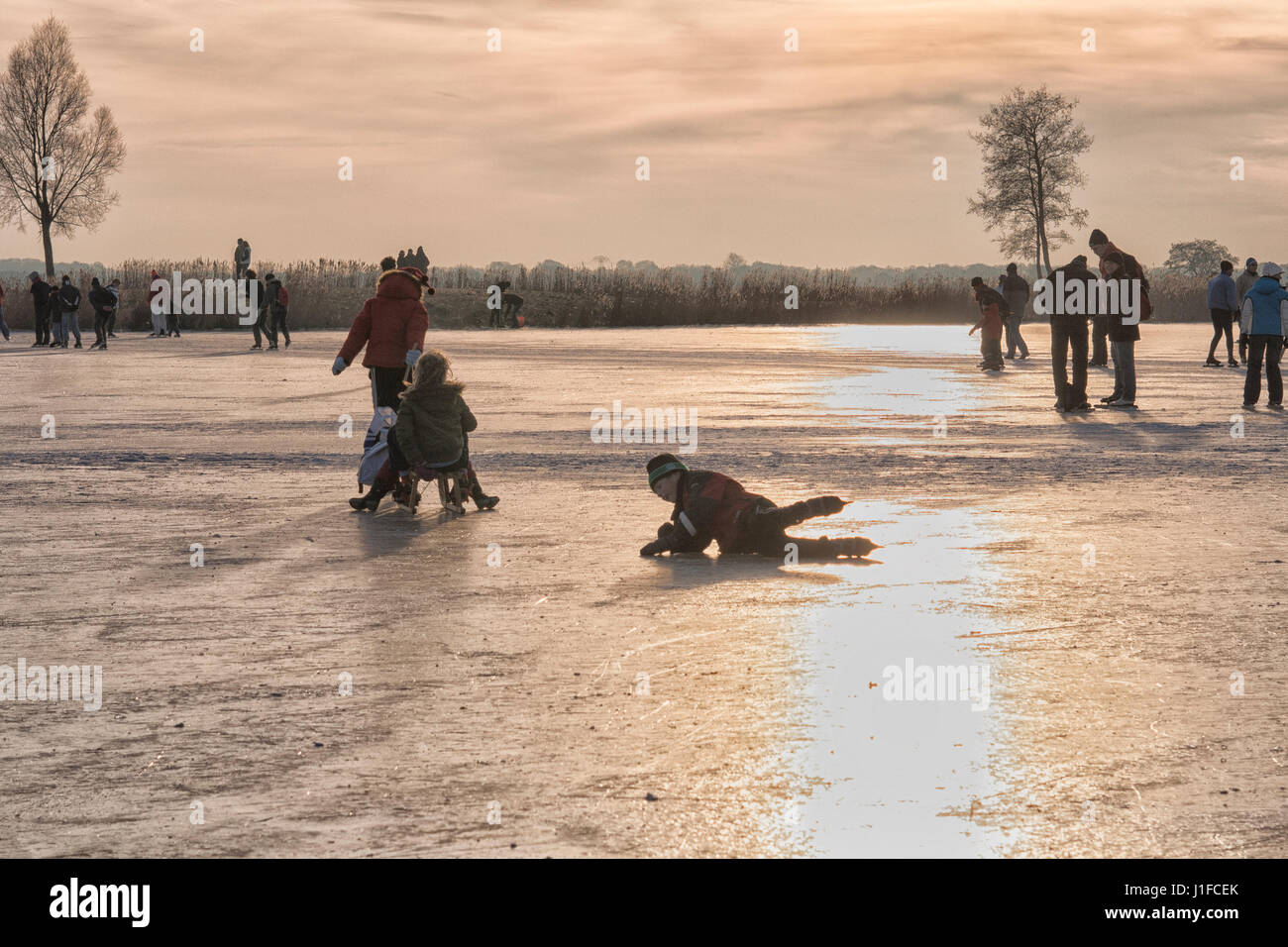 People skating and having fun on a frozen lake Stock Photo - Alamy