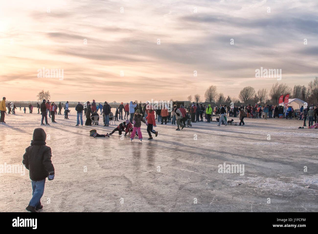 People skating and having fun on a frozen lake Stock Photo - Alamy