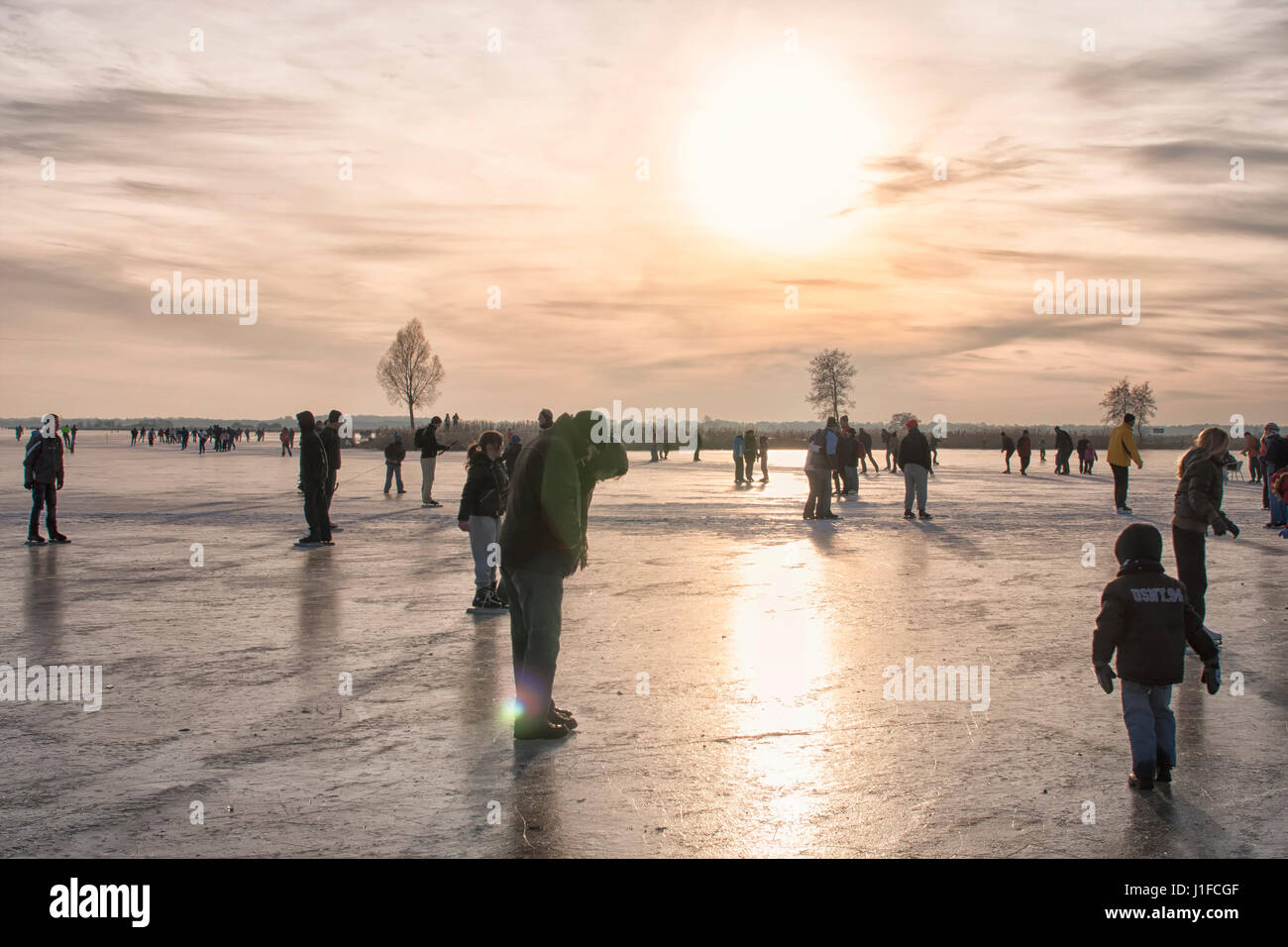 People skating and having fun on a frozen lake Stock Photo - Alamy