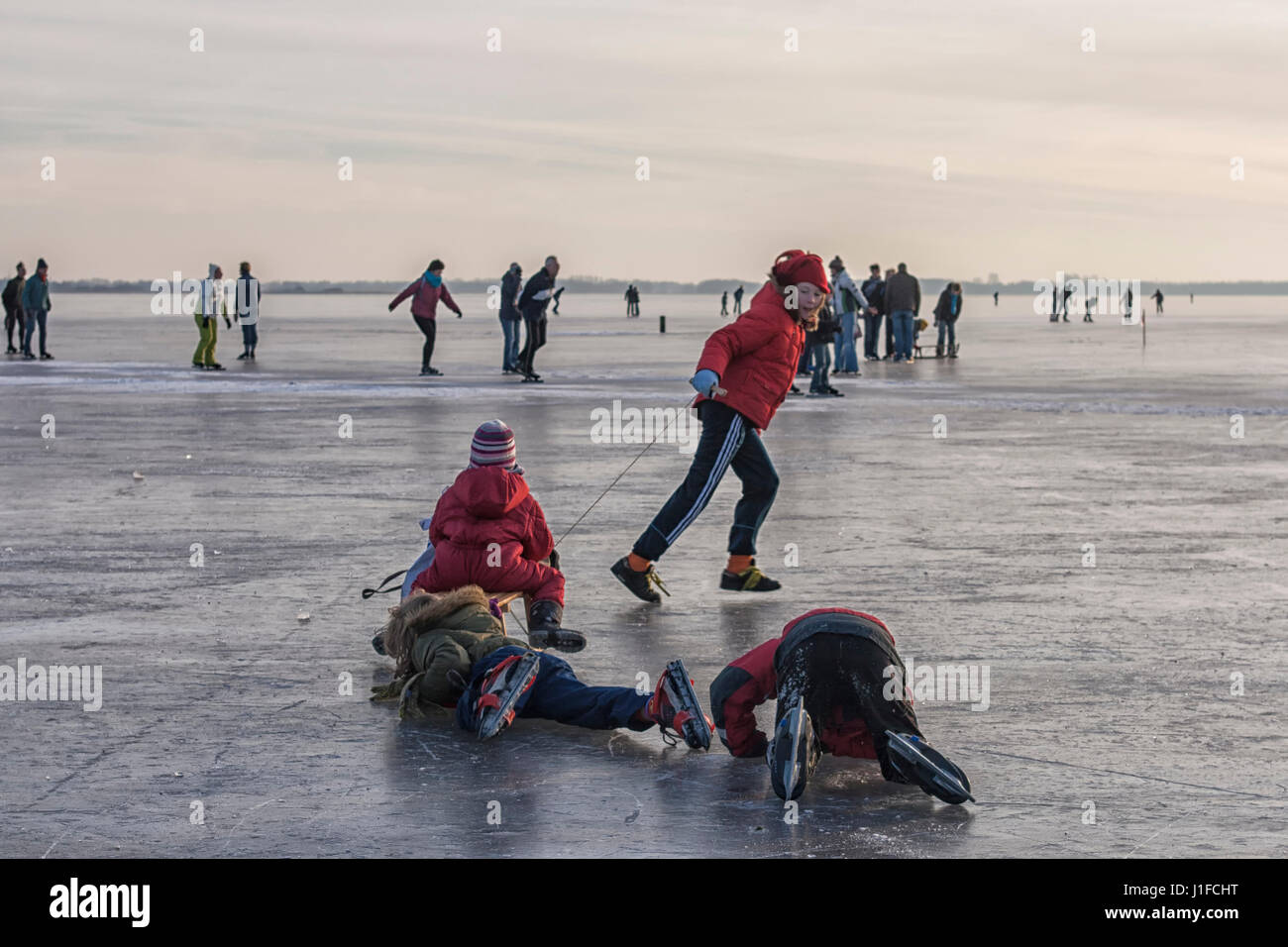 People skating and having fun on a frozen lake Stock Photo - Alamy