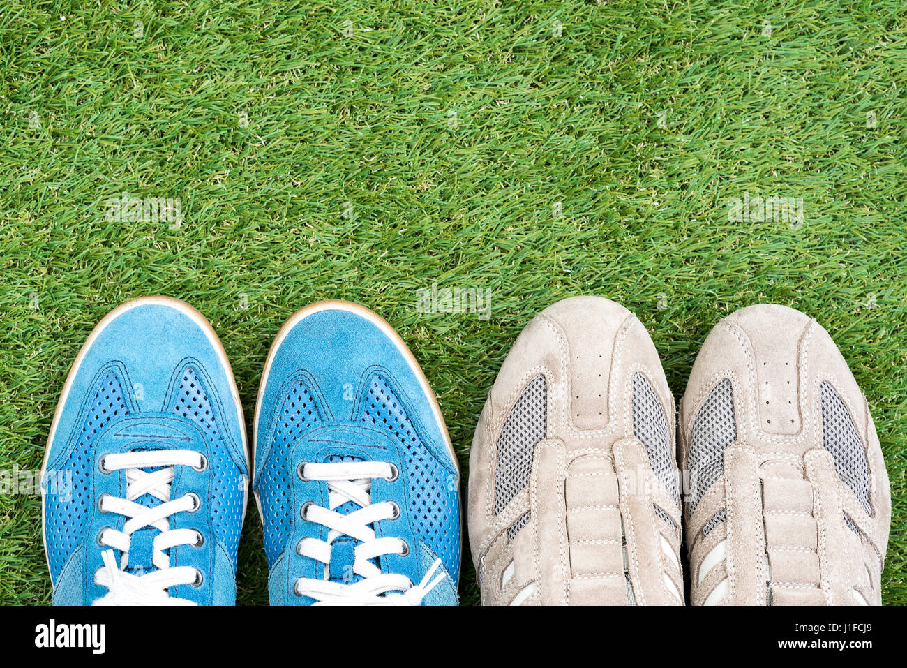 two sneaker leather shoes over green grass field, keep walking concept Stock Photo
