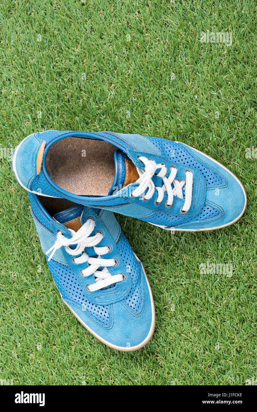 Close up casual men’s fashion shoes, trendy blue sneaker on grass field with copy space Stock Photo