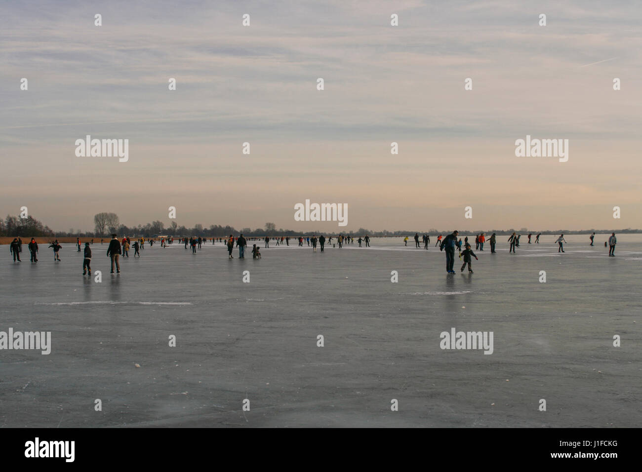 People skating and having fun on a frozen lake Stock Photo - Alamy