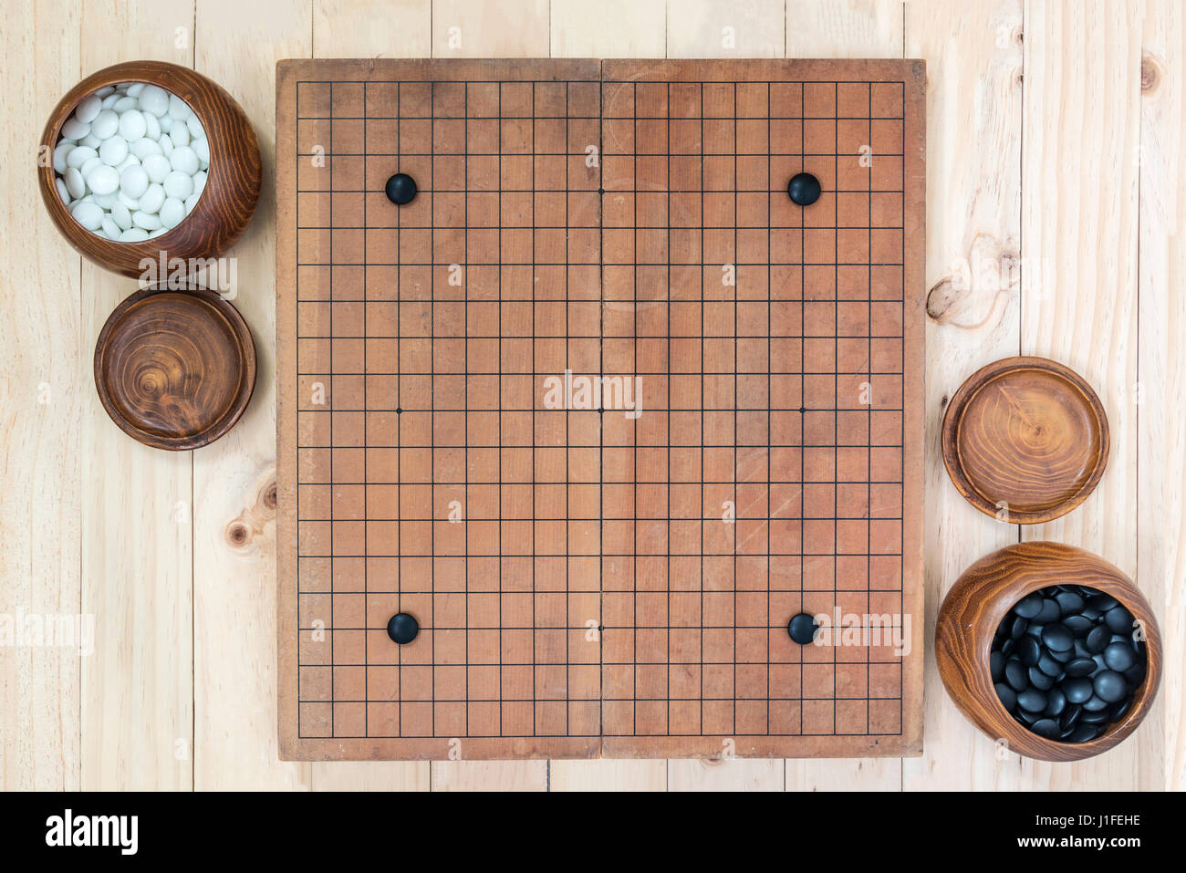 Handicap four stones on go game board with two bowl for black and white