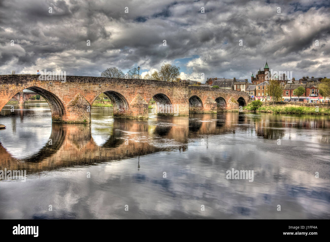 High Dynamic Range image of Devorgilla Bridge (Auld Brig) Dumfries, Scotland. The turrets of the Sherriff Court are visible in the background. Stock Photo