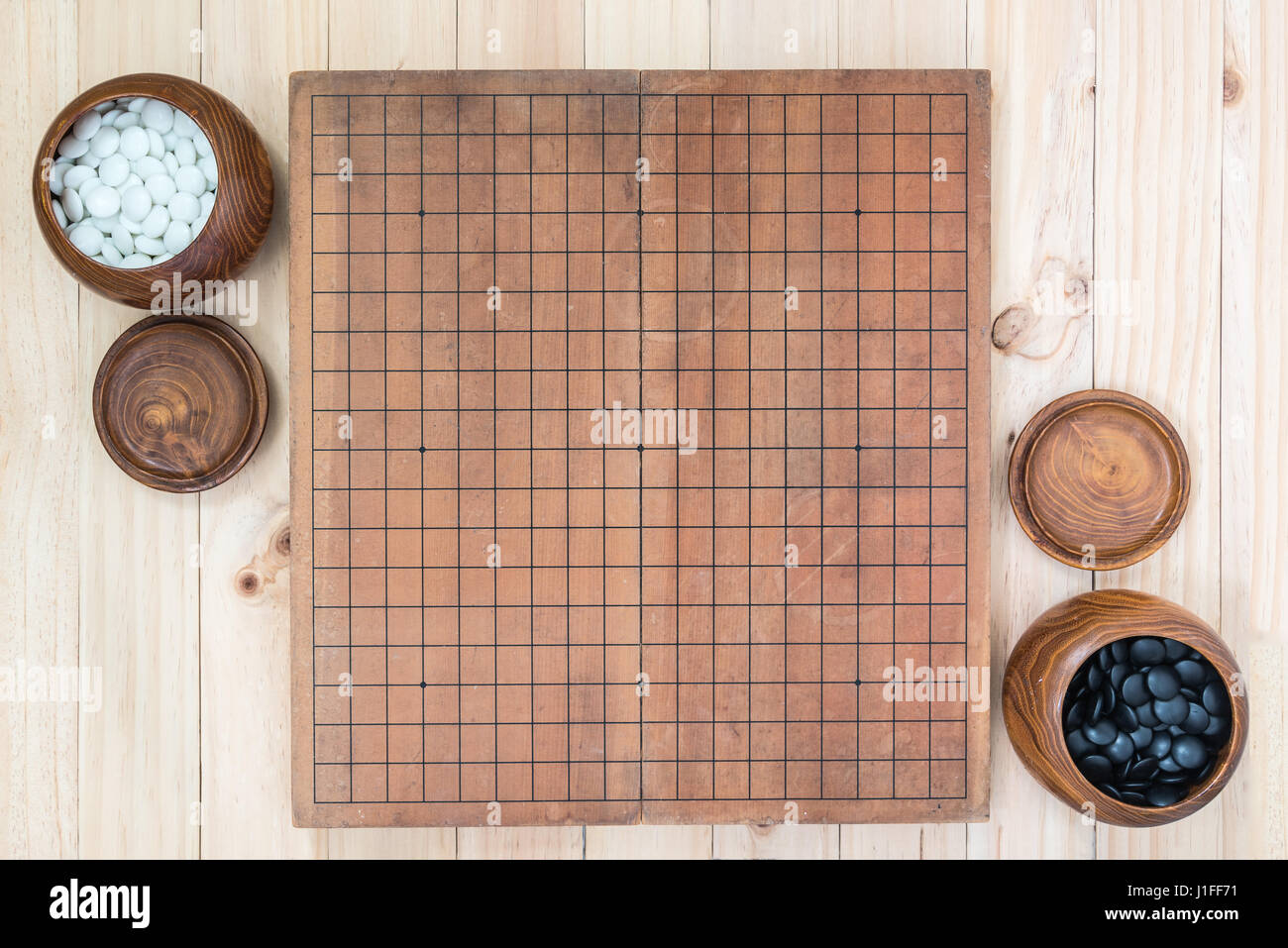 top view two wooden bowls filled black and white stones with empty go ...
