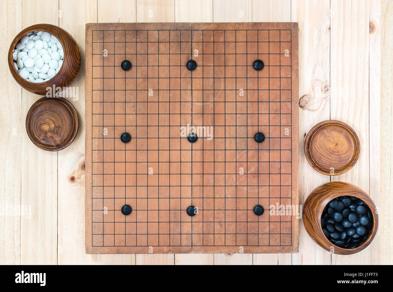 top view two wooden bowls filled black and white stones with nine ...