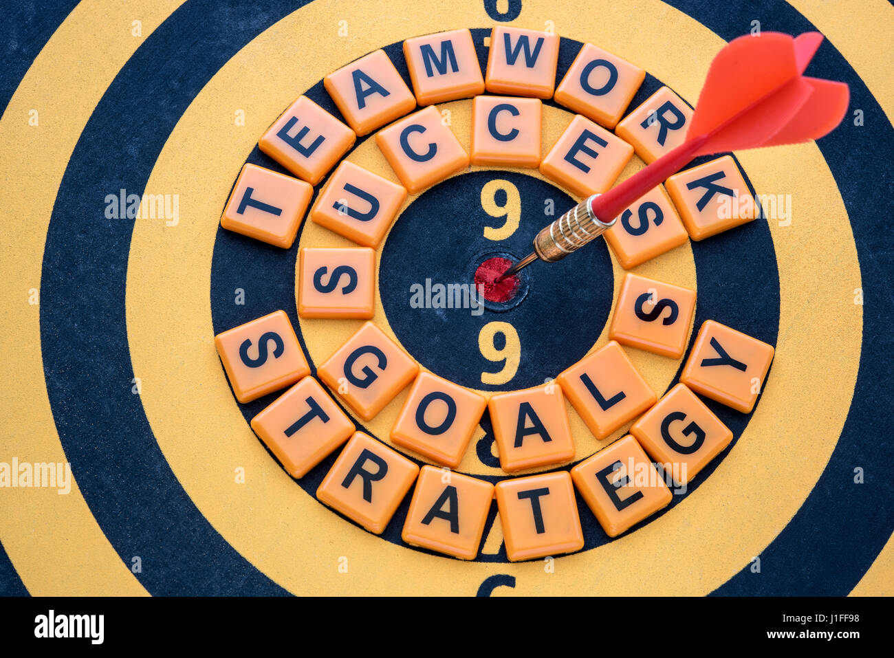 dart target on bullseye with success goals teamwork strategy words, Goal target success business investment financial strategy concept, abstract backg Stock Photo