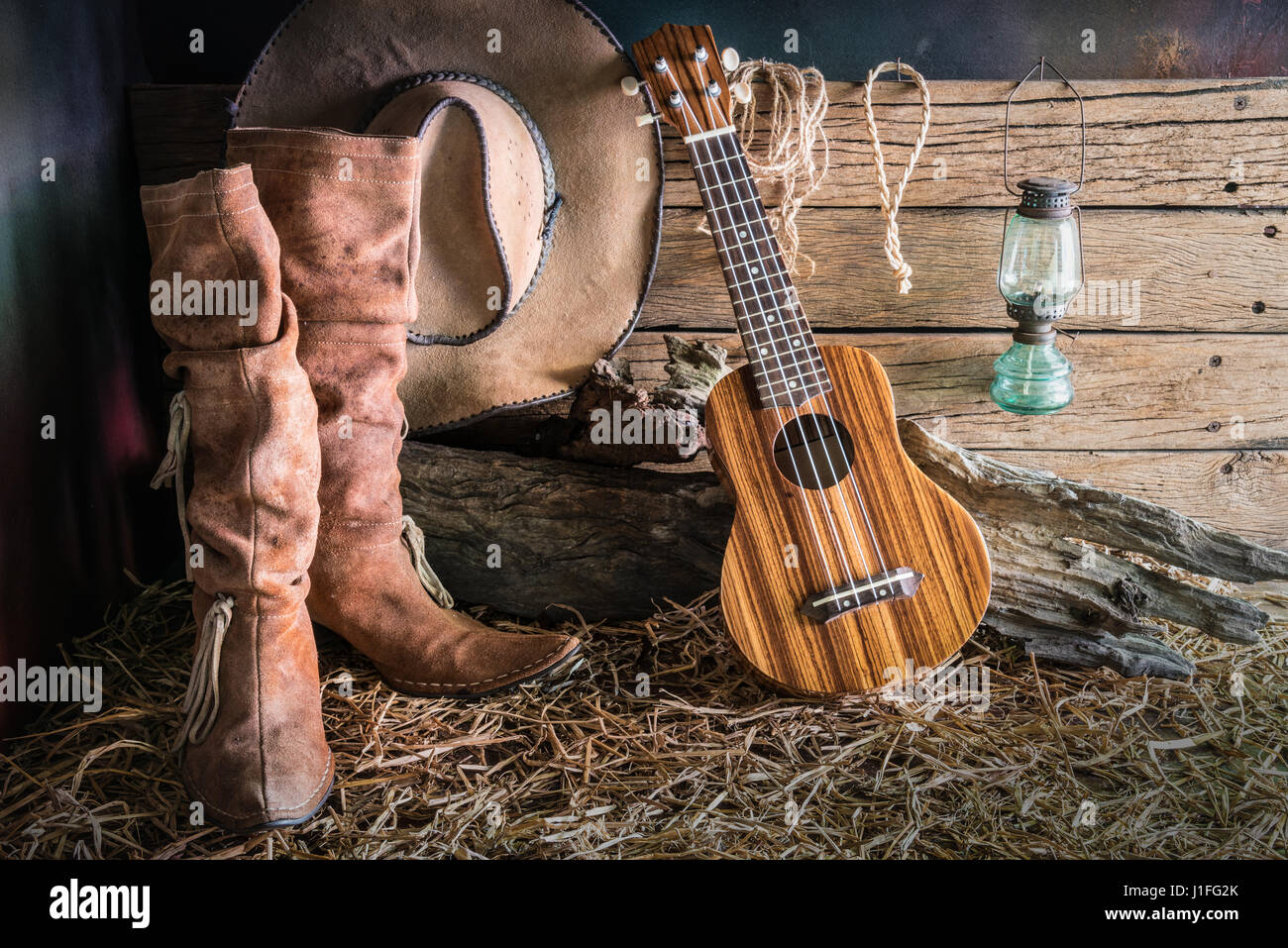 Slik Sway det er smukt Still life painting photography with ukulele on american west rodeo brown  felt cowboy hat and traditional leather boots in vintage ranch barn  backgrou Stock Photo - Alamy