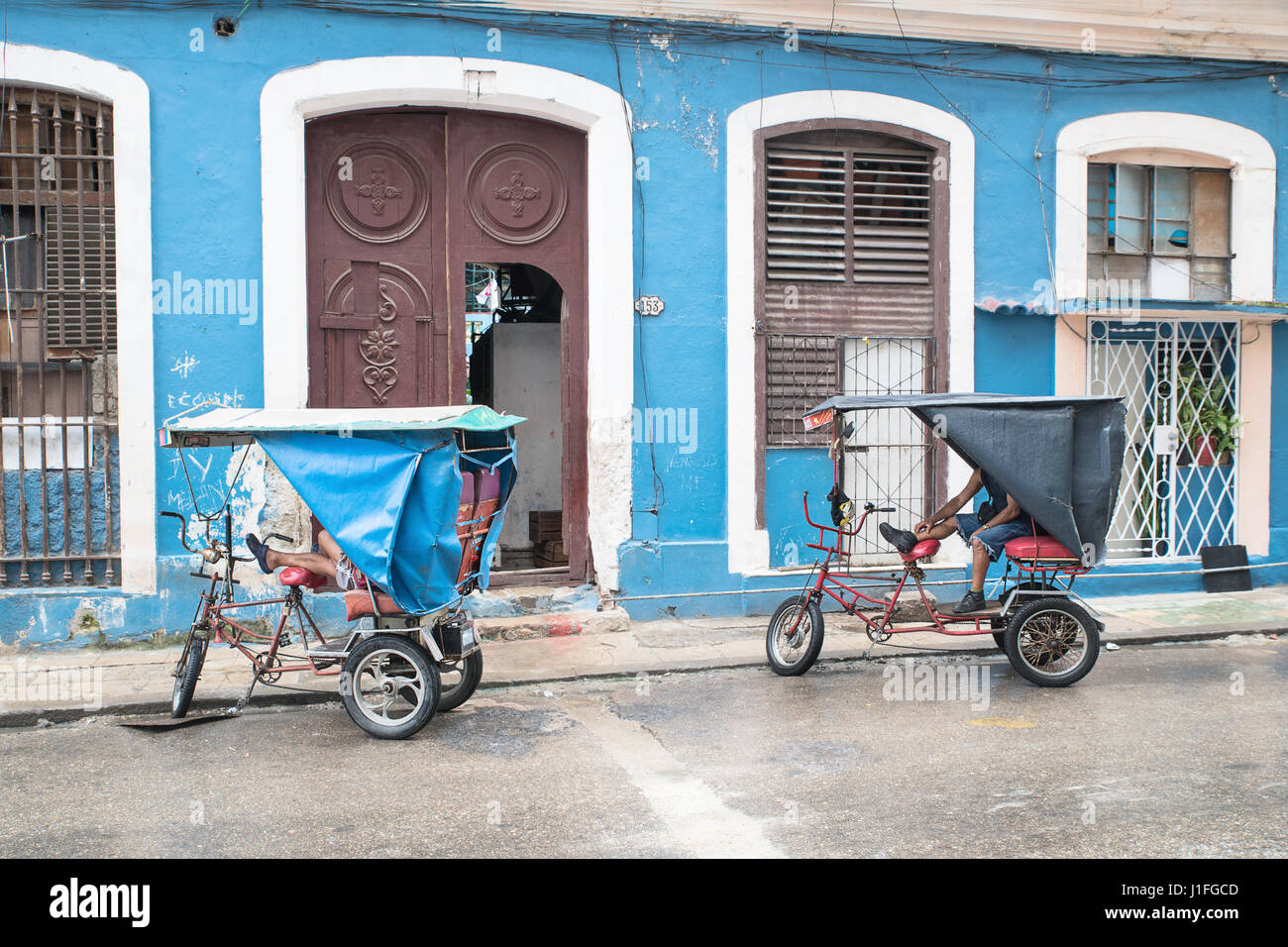 havana  bicyle taxis  waiting in front of a colonial building Stock Photo