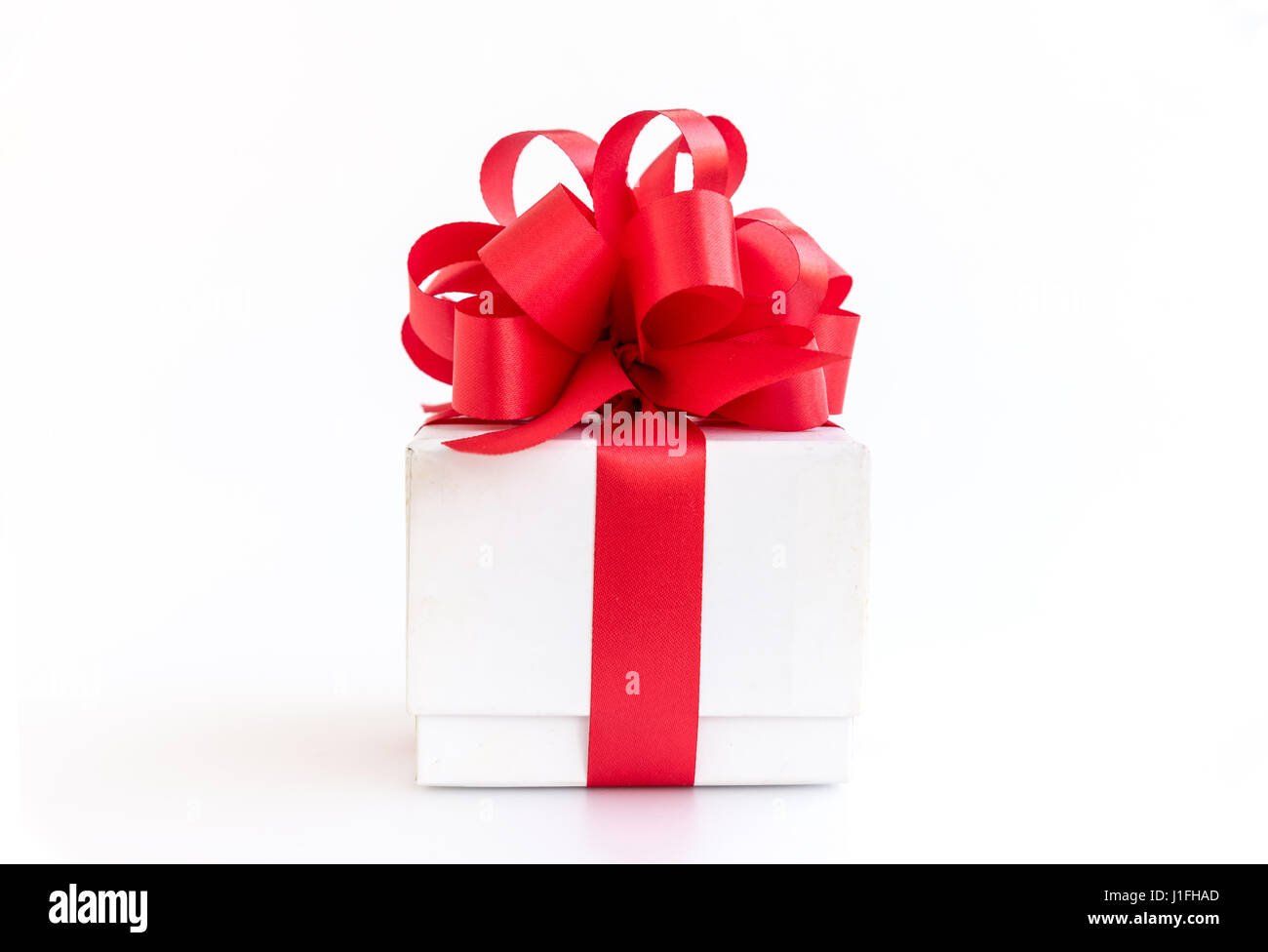 white gift box with red ribbon bow on white background Stock Photo - Alamy