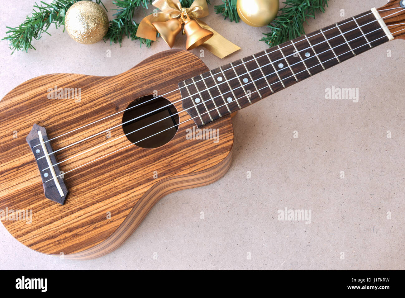 The Ukulele On The Wooden Table With Christmas Golden Decoration Ukulele Is A Gift From The Christmas Day Stock Photo Alamy