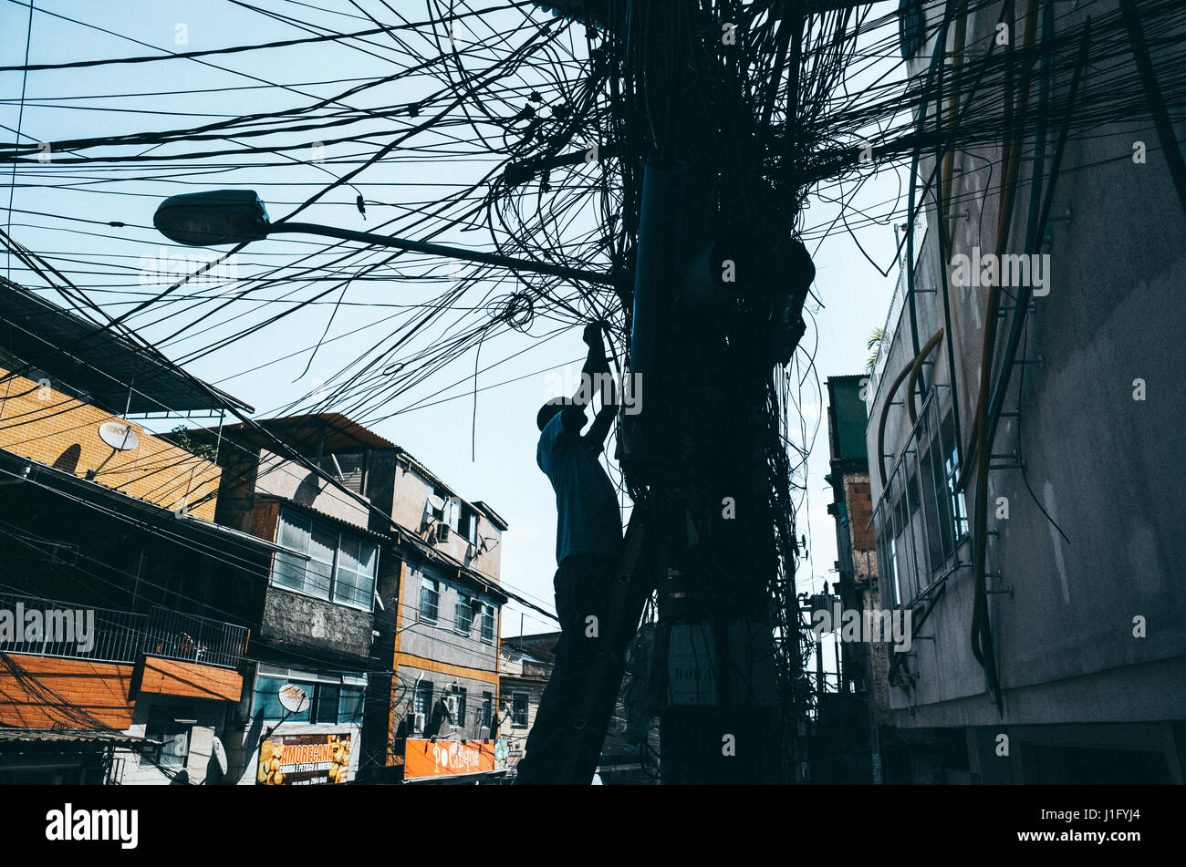 Electrician works on illegal wires in the rocinha favela, rio de janeiro, brazil Stock Photo