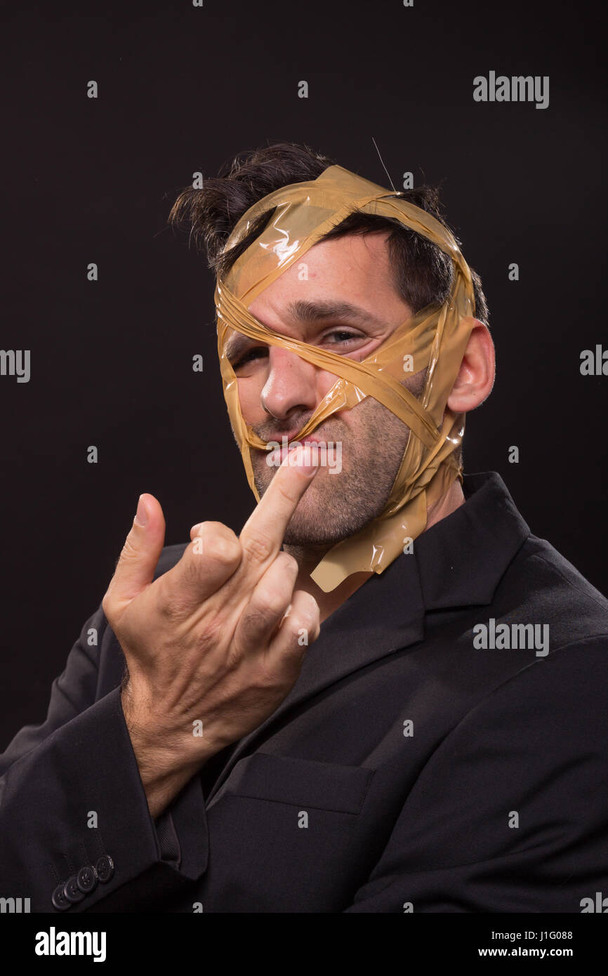 head face wrapped duct tape young man middle finger gesture Stock Photo