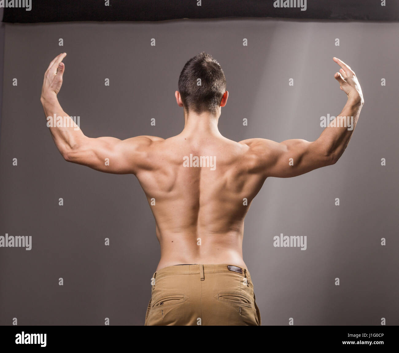 Rear View Of Healthy Muscular Young Man With His Arms Stretched