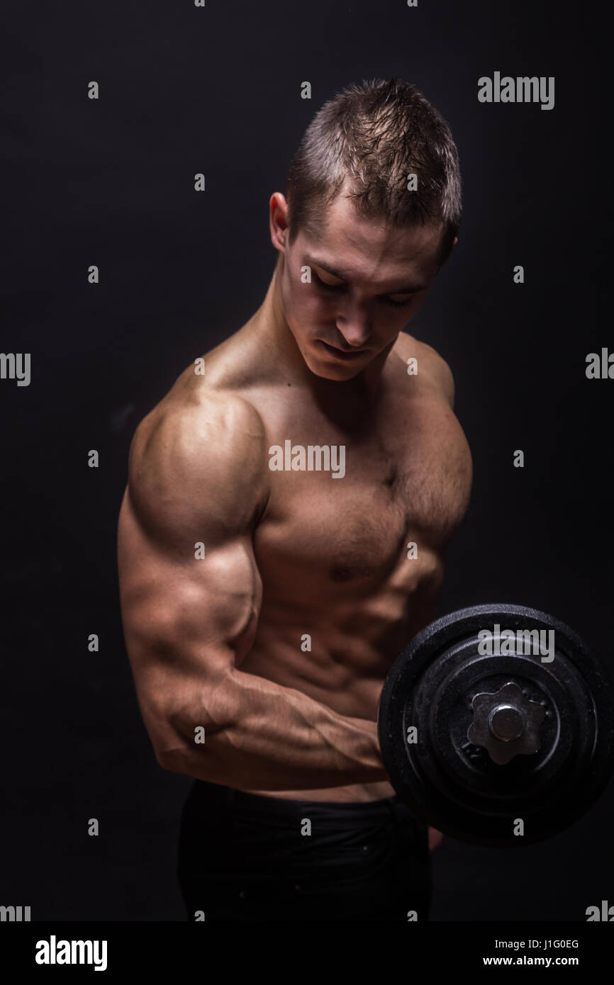 side view, profile young bodybuilder arm dumbbell biceps. studio, black  background Stock Photo - Alamy
