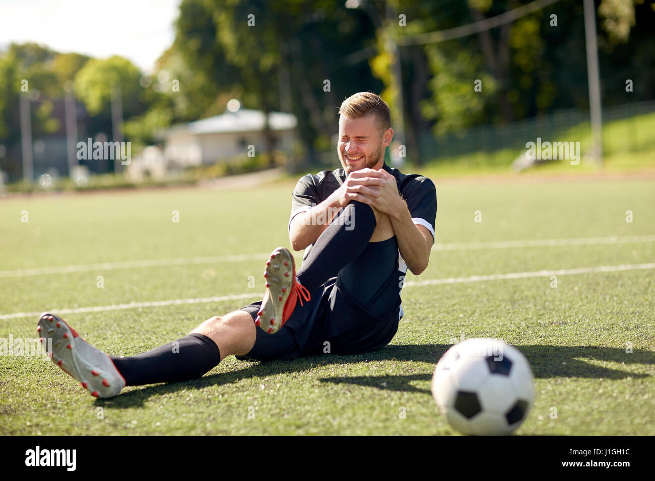 injured soccer player with ball on football field Stock Photo Alamy