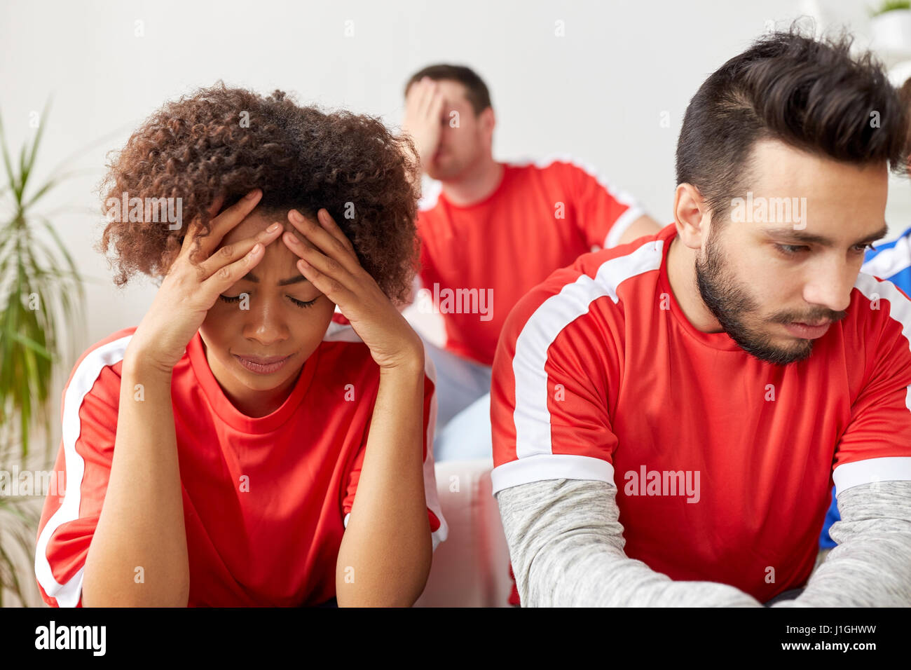 sad friends or football fans at home Stock Photo