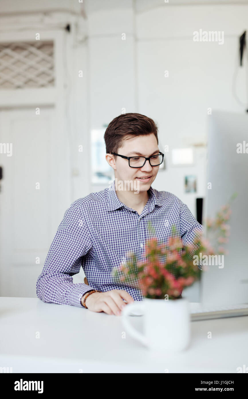 Casual designer working in office, typing on keyboard Stock Photo