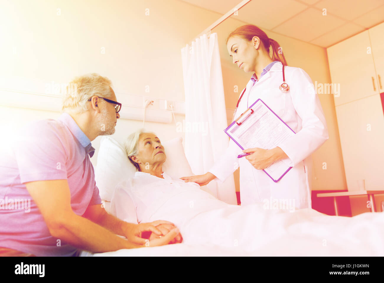 senior woman and doctor with clipboard at hospital Stock Photo