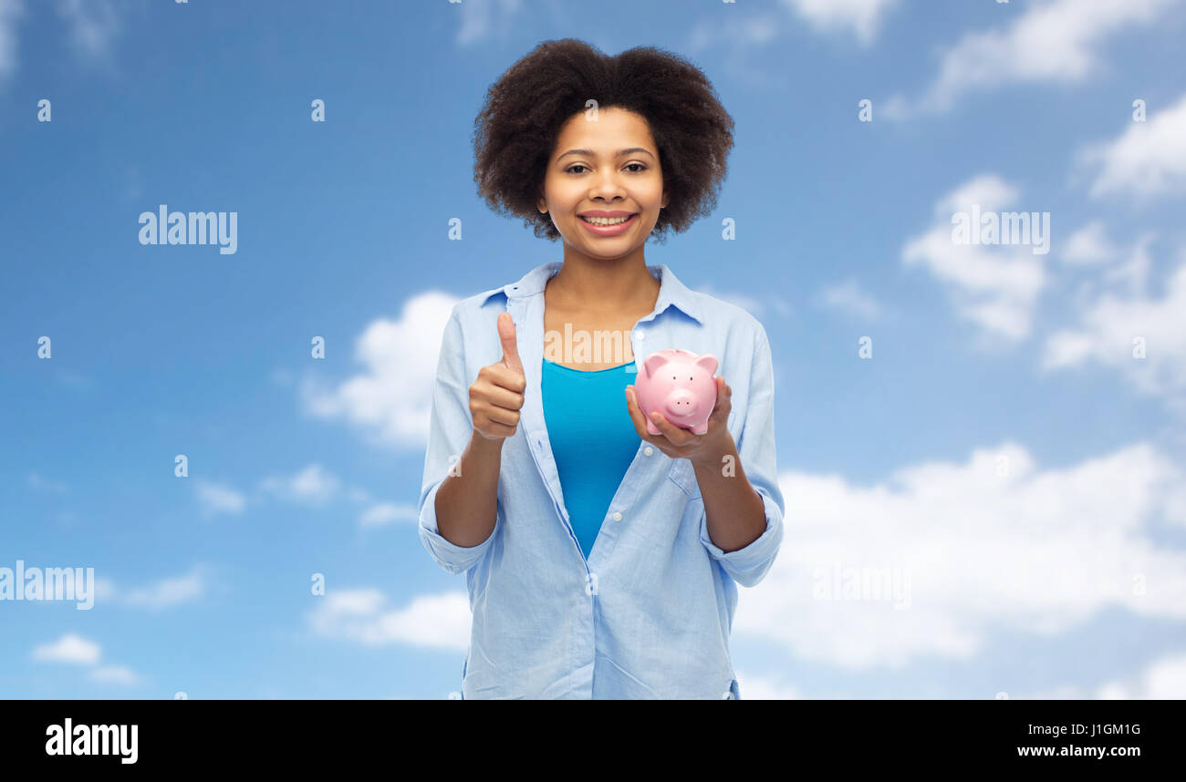 happy woman with piggy bank showing thumbs up Stock Photo - Alamy