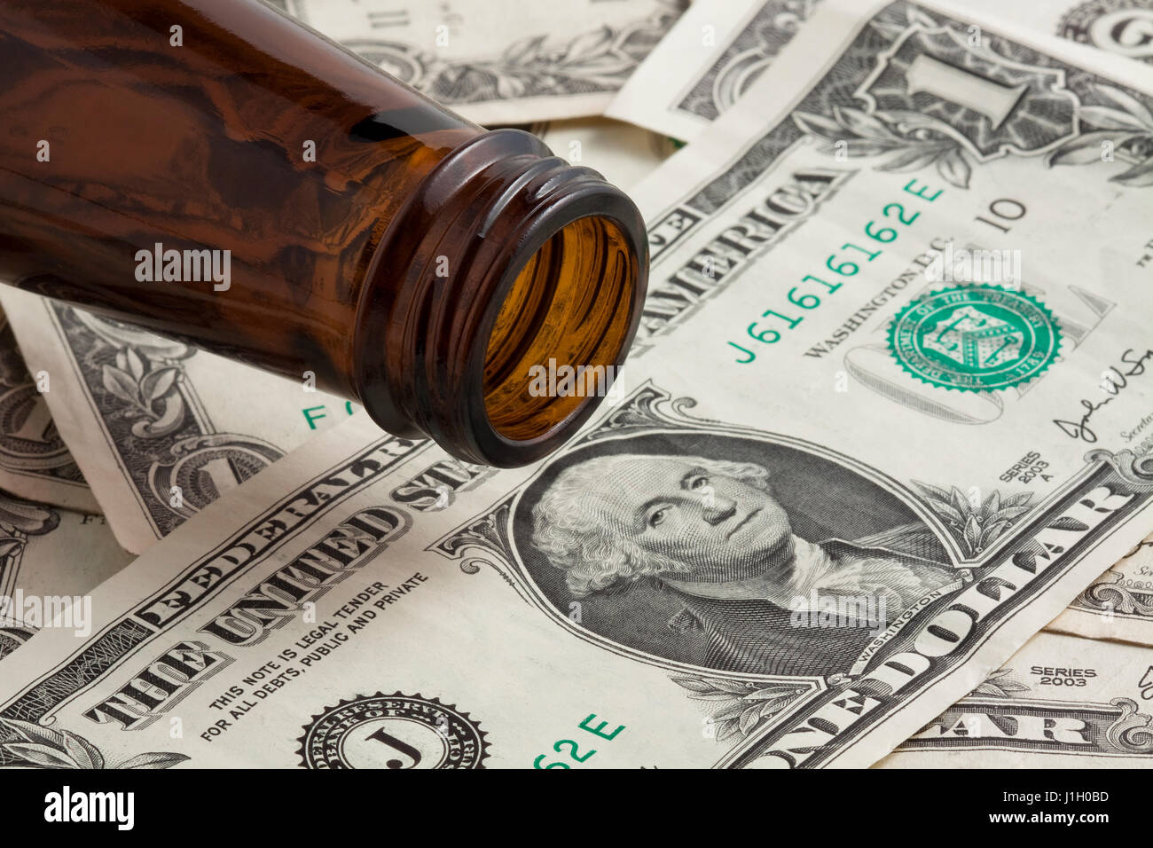 Beer Money An empty beer bottle on dollar bills Stock Photo Alamy