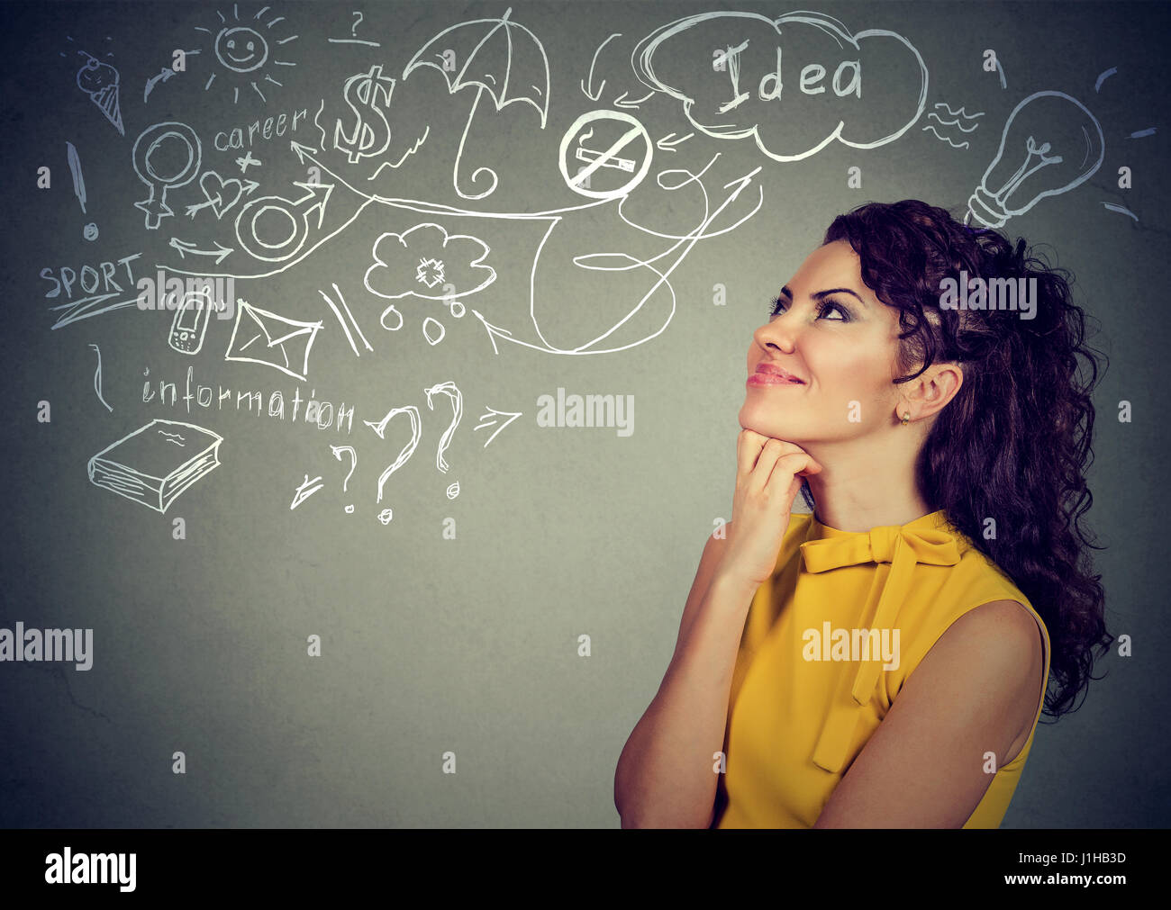 Portrait of a woman thinking dreaming has many ideas looking up at plan isolated on gray wall background. Decision making process concept Stock Photo