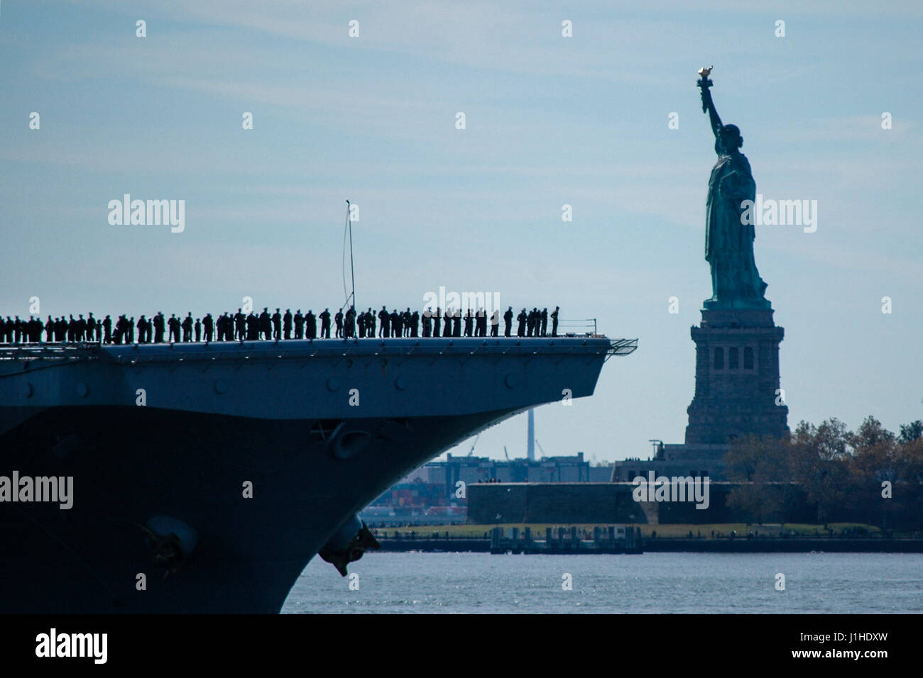 USS Iwo Jima (LHD 7) sails past the Statue of Liberty as it enters New York Harbor, USA Stock Photo